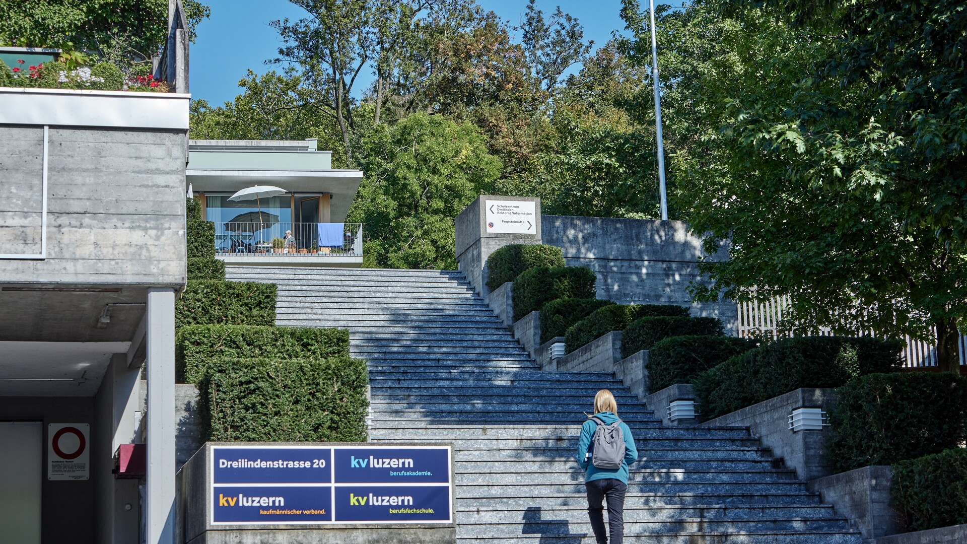 Standort an der Dreilindenstrasse Eine Person geht eine Treppe vor einem Gebäude der KV Luzern hinauf.